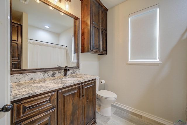 5112 Remington St, Texarkana, TX 75503 - bathroom with wood finished floors, baseboards, vanity, and toilet