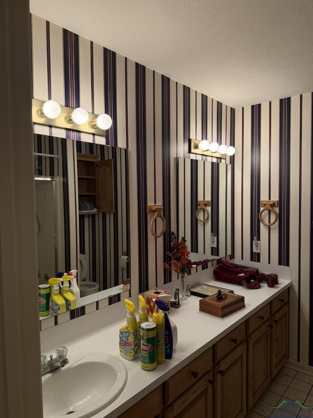 bathroom featuring tile patterned floors, vanity, and a textured ceiling