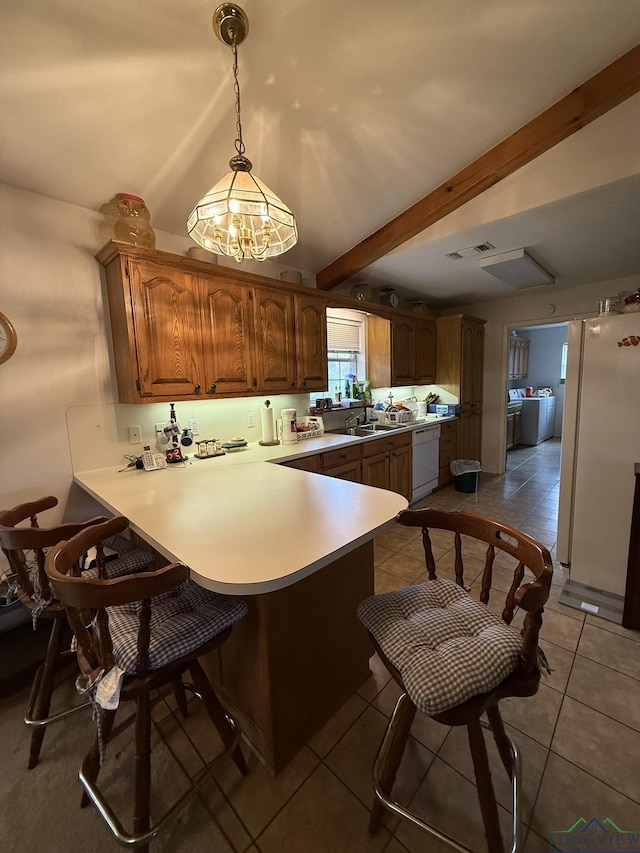 kitchen featuring beamed ceiling, kitchen peninsula, pendant lighting, white appliances, and light tile patterned flooring