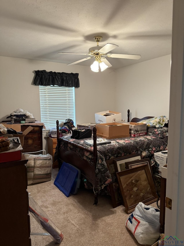 carpeted bedroom with ceiling fan and a textured ceiling