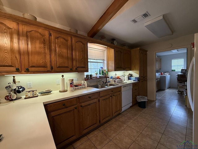 kitchen featuring light tile patterned flooring, white dishwasher, sink, beam ceiling, and washing machine and clothes dryer