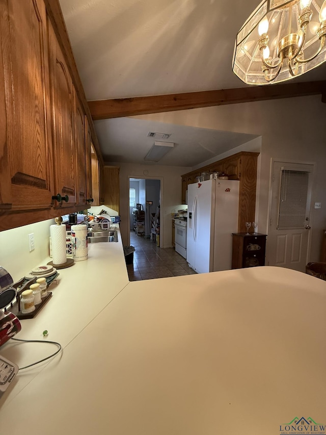 kitchen with white appliances, decorative light fixtures, dark tile patterned flooring, a notable chandelier, and beamed ceiling