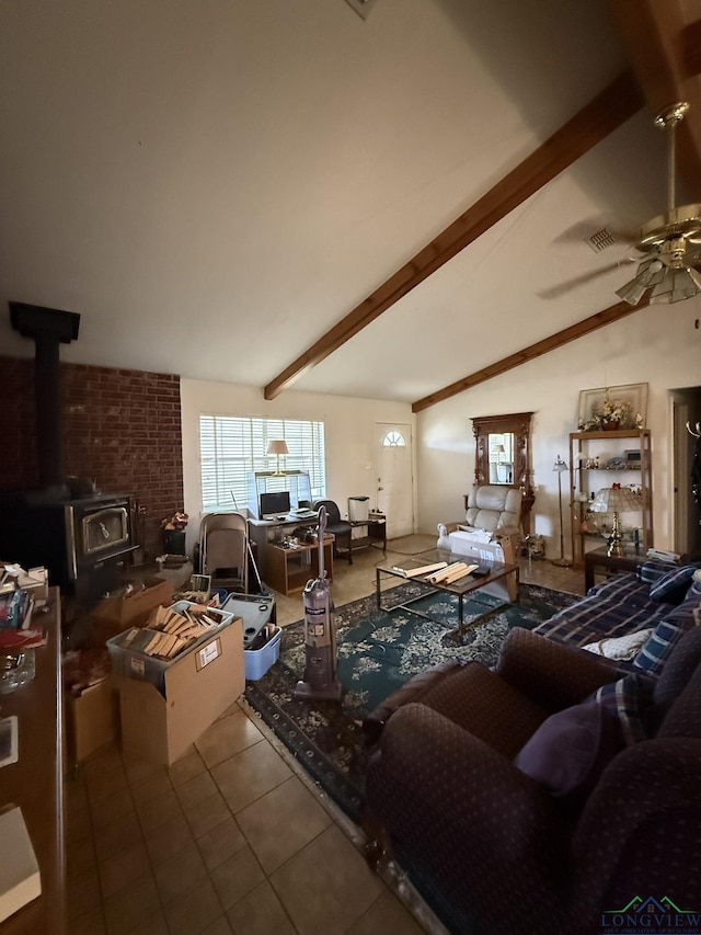 tiled living room with a wood stove, ceiling fan, and vaulted ceiling with beams