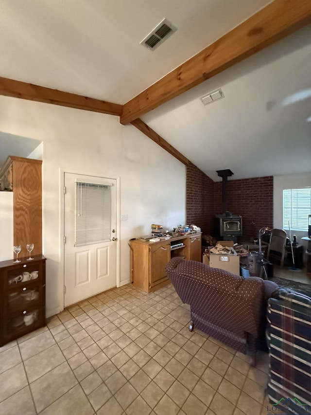 living room with lofted ceiling with beams, light tile patterned flooring, and a wood stove