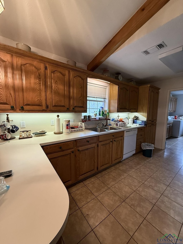 kitchen featuring dishwasher, beam ceiling, light tile patterned floors, and sink