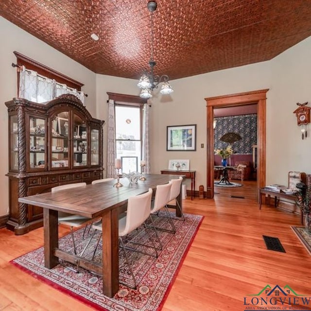 dining space with an inviting chandelier and hardwood / wood-style floors