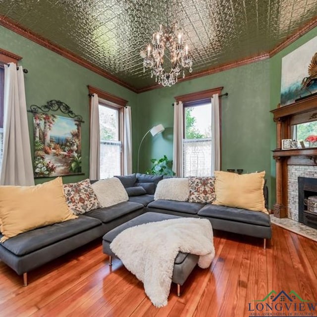 living room with hardwood / wood-style flooring, ornamental molding, a fireplace, and plenty of natural light