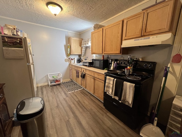 kitchen featuring black appliances, a textured ceiling, crown molding, and hardwood / wood-style floors