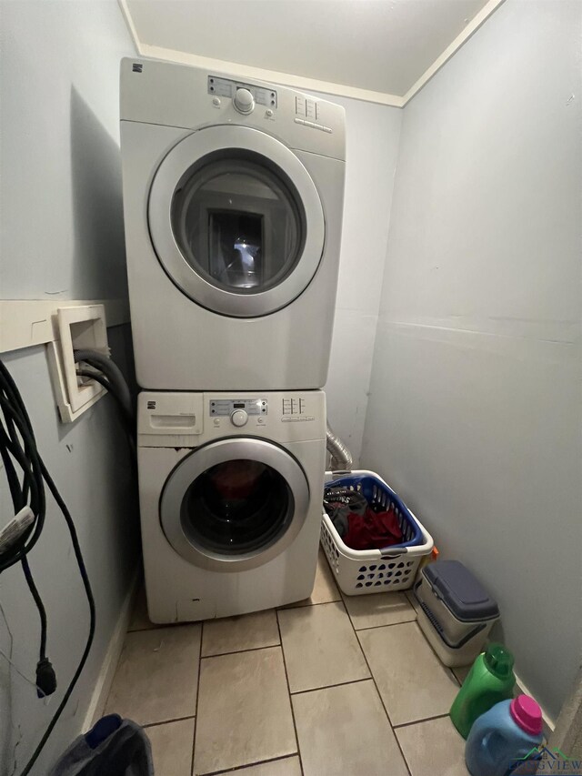 washroom featuring stacked washer / dryer and light tile patterned floors