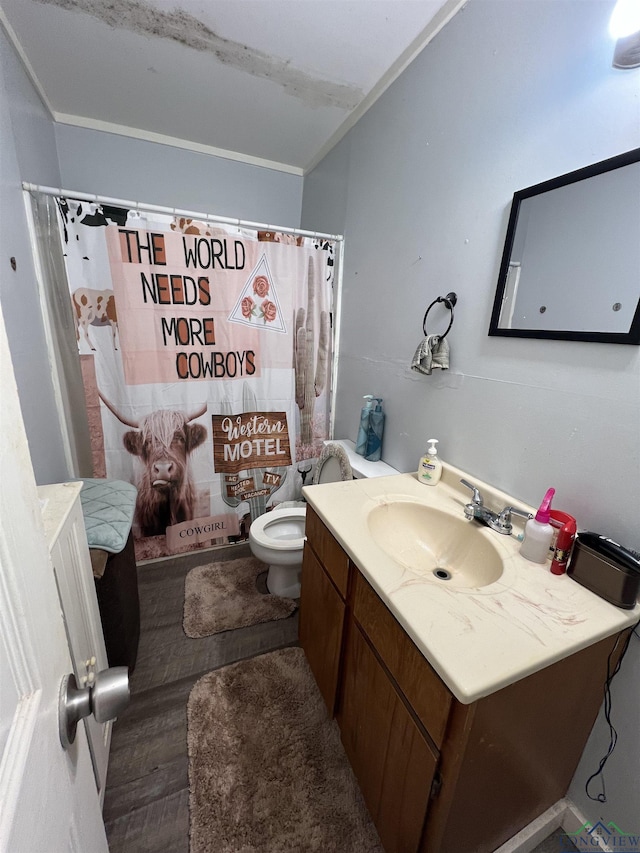 bathroom featuring a shower with curtain, crown molding, wood-type flooring, toilet, and vanity