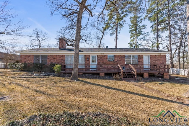 rear view of property featuring a yard and a deck