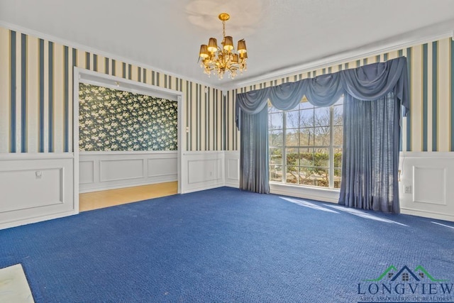 spare room featuring carpet floors and a notable chandelier