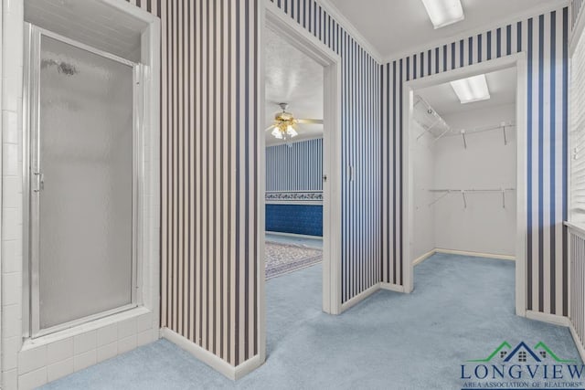 bathroom with a shower with shower door and ornamental molding