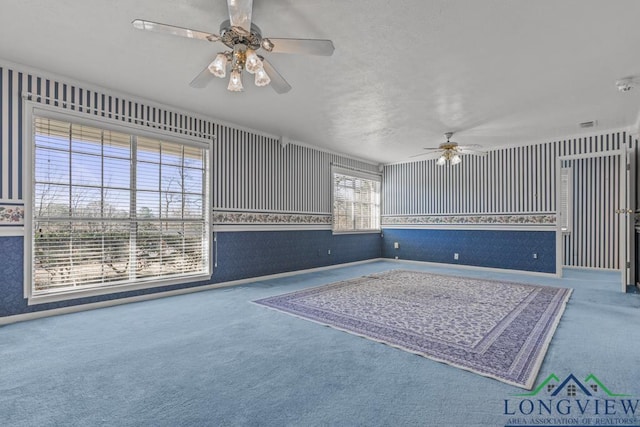 unfurnished living room featuring ceiling fan, carpet, and a healthy amount of sunlight