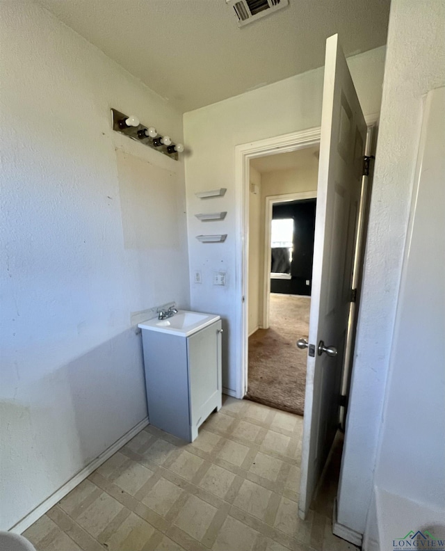 laundry area with sink and light colored carpet