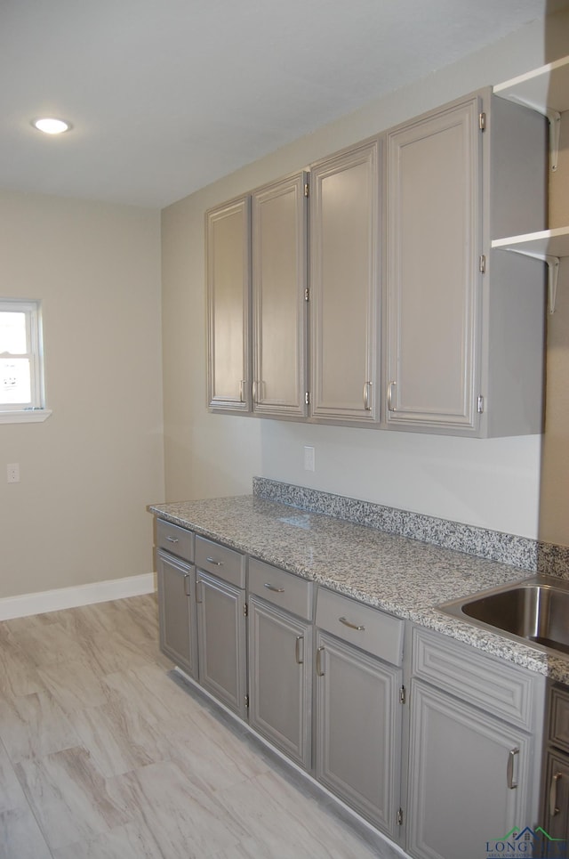 kitchen with light stone counters and gray cabinetry