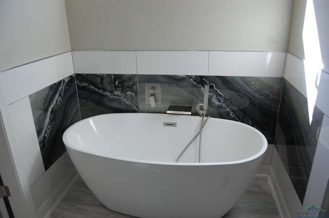 bathroom featuring tile walls and a tub