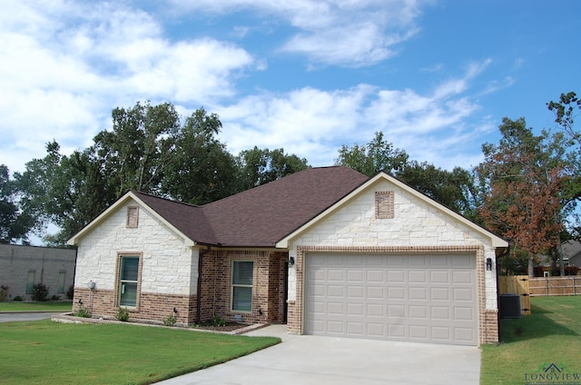 view of front of home featuring a front yard, a garage, and central AC unit