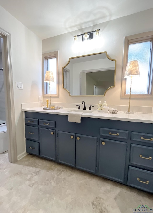 bathroom with a wealth of natural light, vanity, and toilet