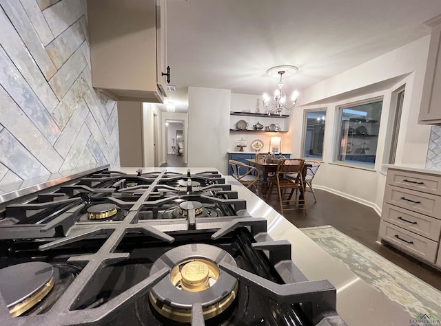 kitchen featuring decorative backsplash, gray cabinets, an inviting chandelier, and hanging light fixtures