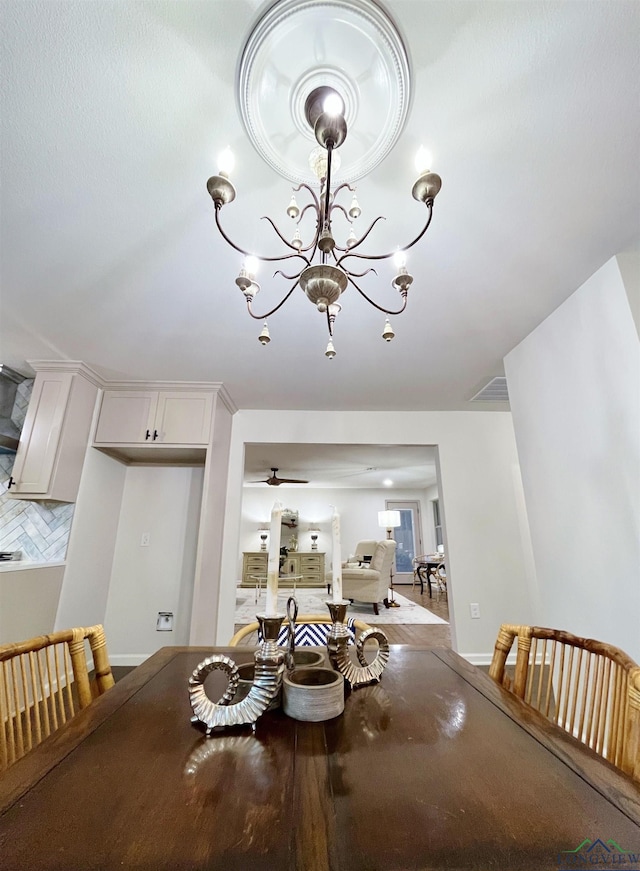 unfurnished dining area with ceiling fan with notable chandelier