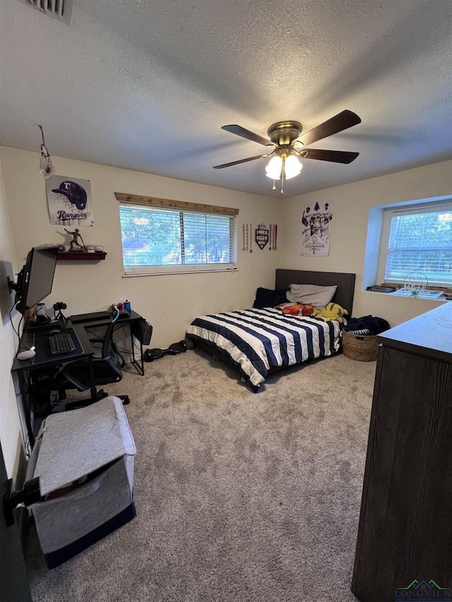 carpeted bedroom with a textured ceiling and ceiling fan