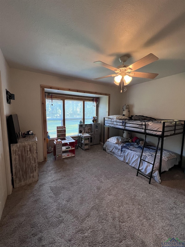 bedroom featuring carpet flooring, ceiling fan, and a textured ceiling