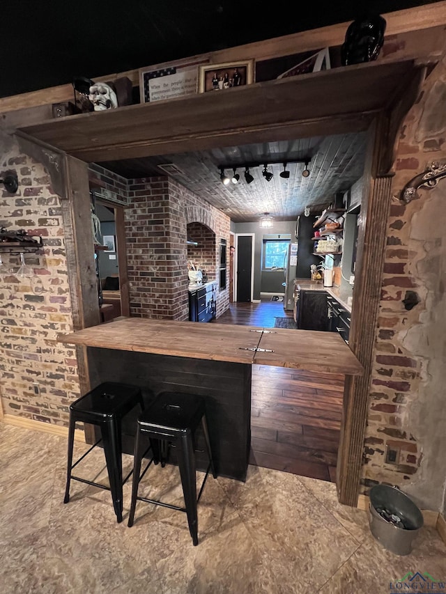 bar featuring brick wall and wooden counters