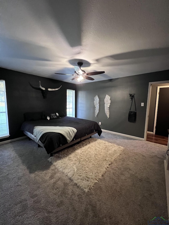 unfurnished bedroom with a textured ceiling, carpet floors, and ceiling fan