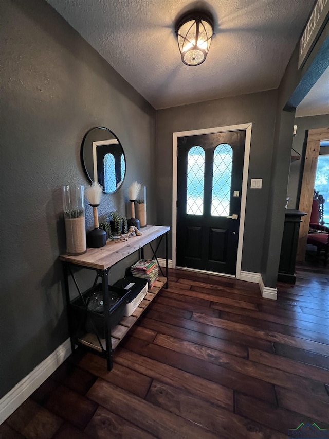 entrance foyer with a textured ceiling and dark hardwood / wood-style flooring