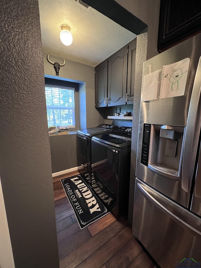 laundry area featuring a textured ceiling, cabinets, washer and dryer, and dark hardwood / wood-style floors