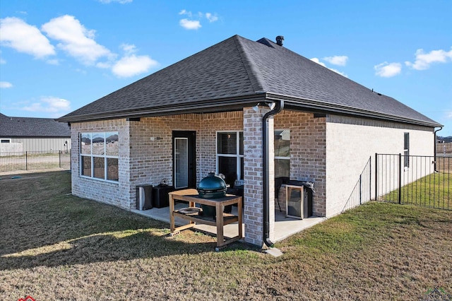 rear view of house with a patio and a lawn