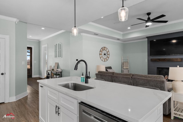 kitchen featuring a large fireplace, a center island with sink, hanging light fixtures, and sink