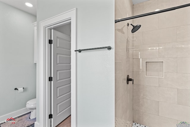 bathroom featuring toilet and tiled shower