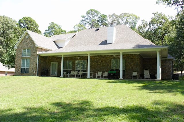 rear view of house featuring a yard and ceiling fan