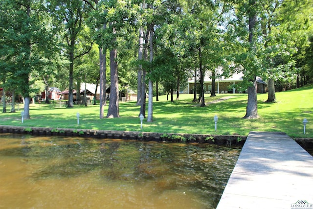 dock area featuring a lawn and a water view