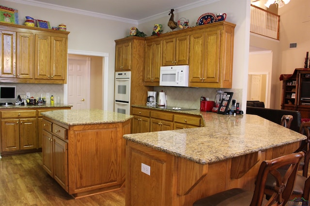 kitchen with tasteful backsplash, a kitchen island, white appliances, and ornamental molding