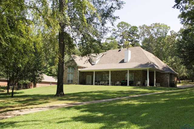 back of property featuring a yard