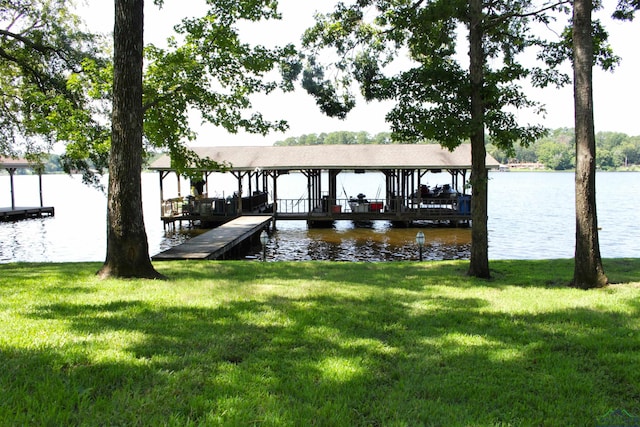 dock area featuring a water view and a yard