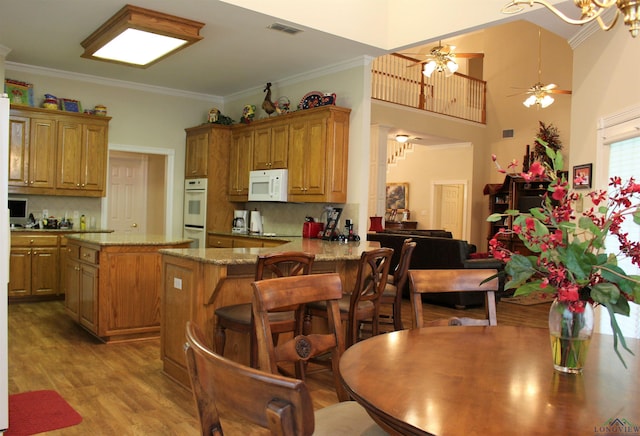 kitchen with white appliances, a center island, light hardwood / wood-style flooring, and tasteful backsplash