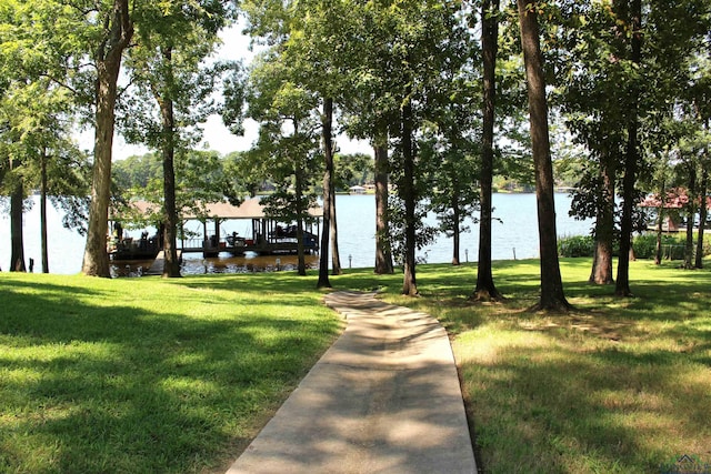 surrounding community featuring a lawn and a water view