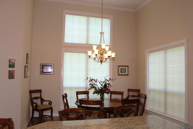 dining area with hardwood / wood-style floors, a notable chandelier, and crown molding