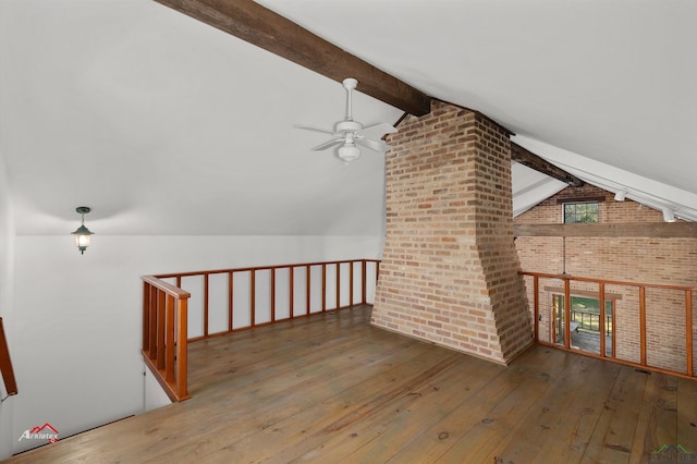 additional living space with hardwood / wood-style flooring, vaulted ceiling with beams, ceiling fan, and brick wall