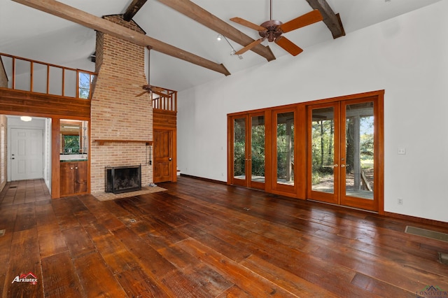 unfurnished living room with ceiling fan, beam ceiling, high vaulted ceiling, a fireplace, and dark hardwood / wood-style floors