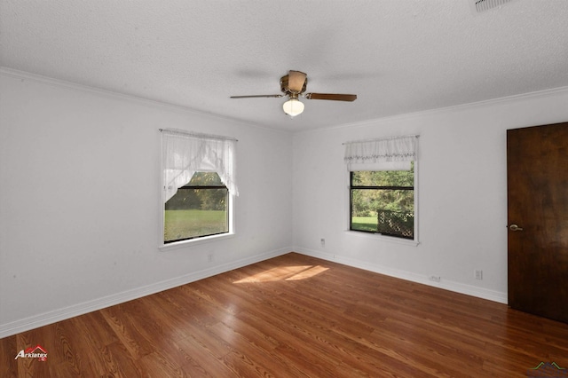 spare room featuring a textured ceiling, ceiling fan, a healthy amount of sunlight, and dark hardwood / wood-style floors