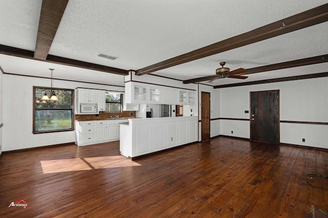 kitchen with dark hardwood / wood-style flooring, beamed ceiling, white cabinets, and a textured ceiling