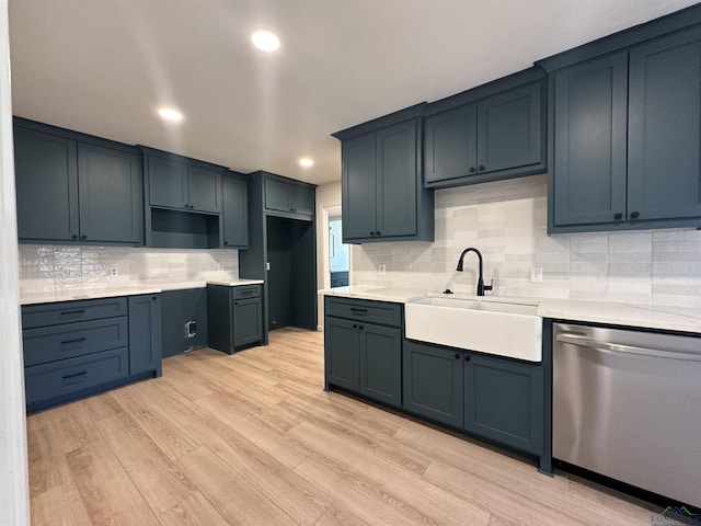 kitchen featuring decorative backsplash, light wood-type flooring, stainless steel dishwasher, and sink