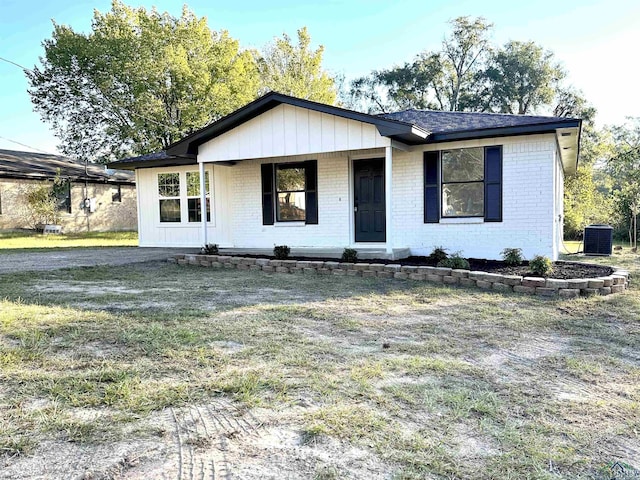 view of front of house with a porch, central air condition unit, and a front yard