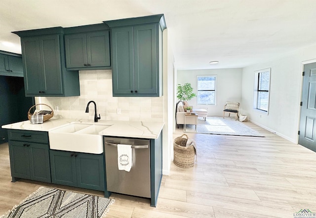 kitchen featuring tasteful backsplash, dishwasher, light hardwood / wood-style floors, and sink