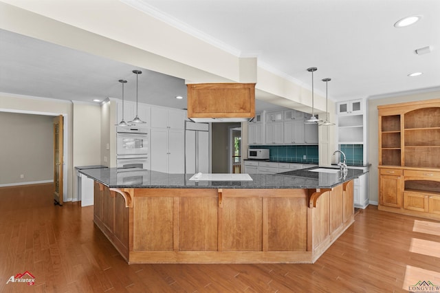 3408 Airline Rd, Longview, TX 75605 - kitchen featuring white appliances, ornamental molding, wood finished floors, a kitchen breakfast bar, and dark stone countertops